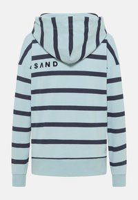 Svetlomodrá mikina s kapucňou a námorníckymi horizontálnymi pruhmi, so šnúrkou na kapucni a vyšitým logom "SAND" na zadnej strane. Mäkký bavlnený materiál.