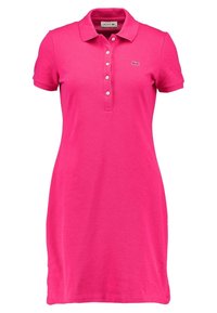 Abito polo in tessuto rosa brillante, con colletto, maniche corte e patta con tre bottoni. Logo Lacoste ricamato sul petto.
