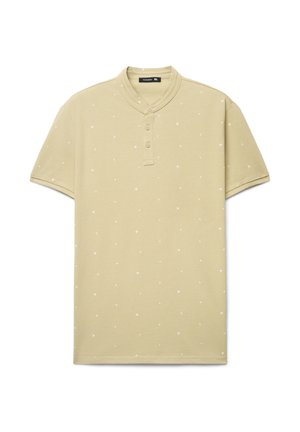 Polo a maniche corte verde oliva con scollo alla henley, caratterizzata da motivi bianchi a forma di stelle e tre bottoni frontali. Tessuto morbido al tatto.