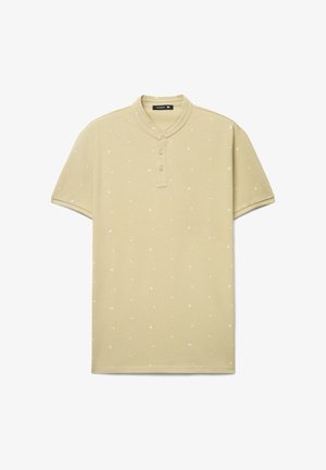 Polo a maniche corte verde oliva con scollo alla henley, caratterizzata da motivi bianchi a forma di stelle e tre bottoni frontali. Tessuto morbido al tatto.