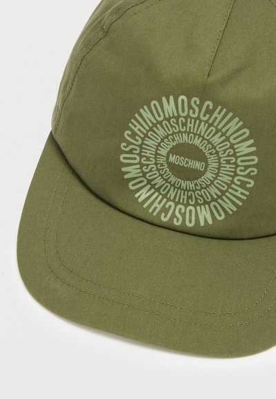 Καπέλο σε ελιά πράσινο με κυρτή γείσο και γυαλιστερά γράμματα. Ο σχεδιασμός περιλαμβάνει επαναλαμβανόμενο κείμενο "MOSCHINO" σε κυκλικό μοτίβο.