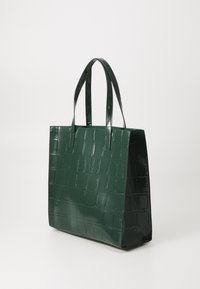 Zeleni patentirani tote bag s teksturom krokodila, pravokutnog oblika i dvije duge ručke. Glatka površina s sjajnim završetkom i izraženim uzorkom.
