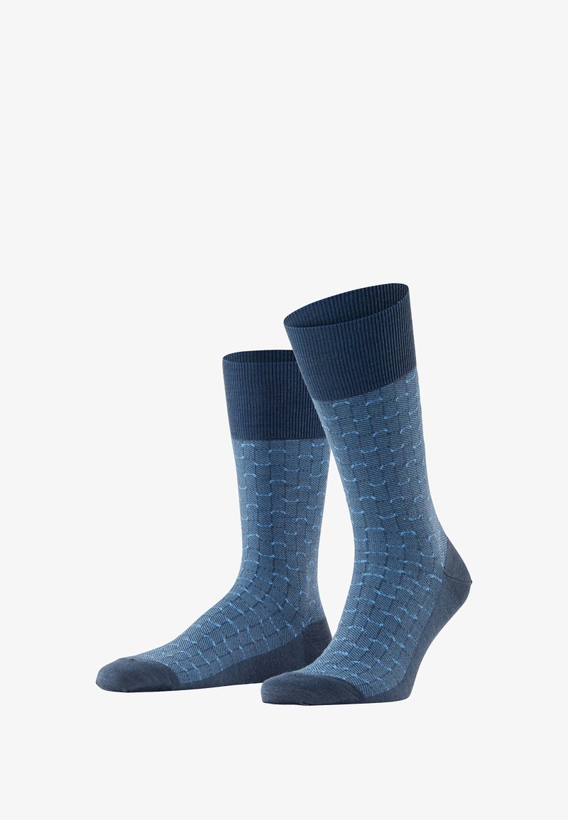 Blaue gemusterte Socken mit geripptem Bund. Sie verfügen über ein geometrisches Design in hellblau auf einem dunkelblauen Hintergrund. Baumwollmischung.