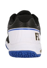 Svart och vit sneaker med en texturerad svart ovandel, vit mellansula med blå accenter och en mönstrad blå gummisula. Guldlogga ingår.