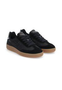 Black suede sneakers with a textured design, featuring a gum rubber sole, flat black laces, and metallic silver accents on the heel.