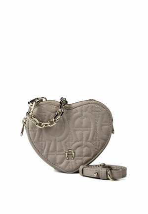 Sac à main en cuir beige en forme de cœur avec motif matelassé, poignée chaîne dorée et bandoulière en cuir amovible sur fond blanc.