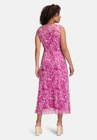 Rosa gemustertes Maxikleid mit taillierter Oberpartie, ärmellosem Design und ausgestelltem Saum, das mit floralen und abstrakten Drucken versehen ist.