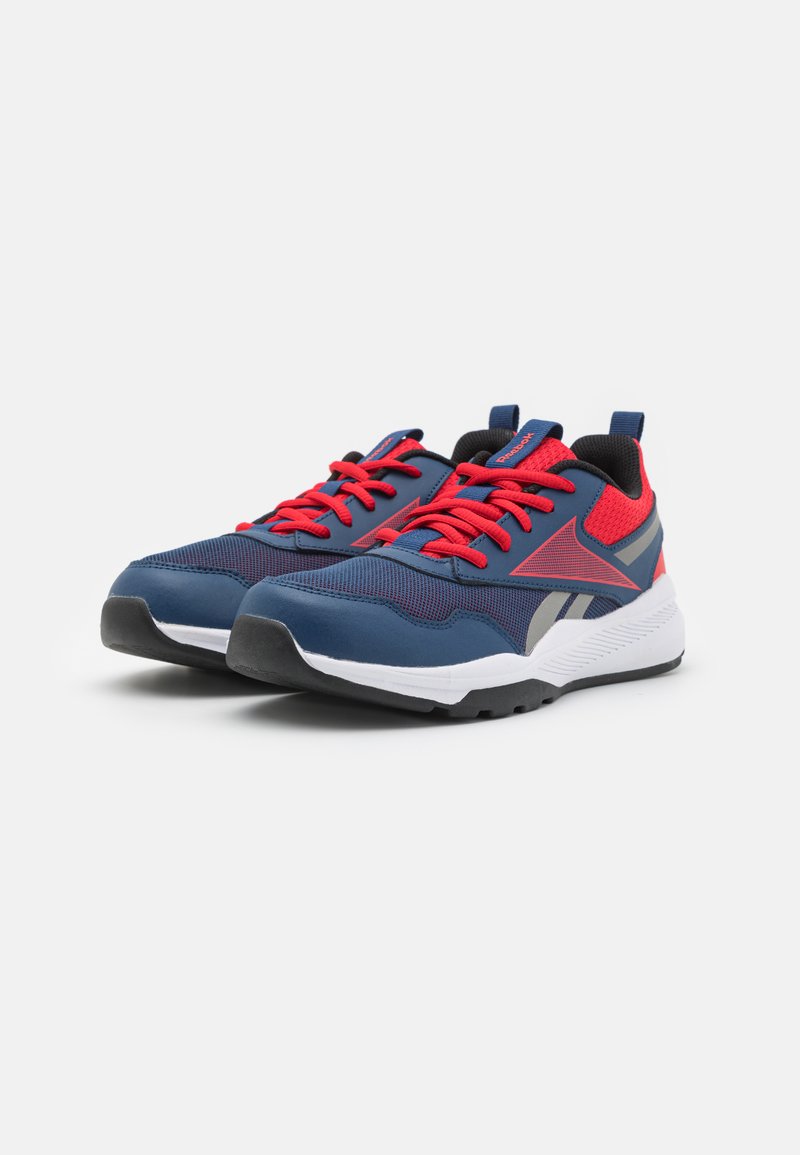 Baskets de sport bleues avec des lacets rouges, tige en maille et synthétique, accents rayés, semelle intermédiaire blanche rembourrée et semelle extérieure en caoutchouc noire.