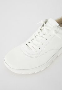 Białe skórzane sneakersy z okrągłym noskiem, sznurowanym zapięciem, przeszywanymi detalami i teksturowaną powierzchnią; lekką gumową podeszwą.