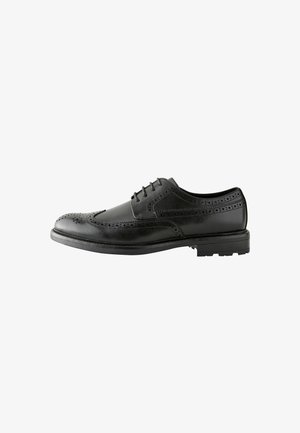 Black leather brogue shoe with decorative perforations, lace-up design, rounded toe, and textured rubber sole for added grip.