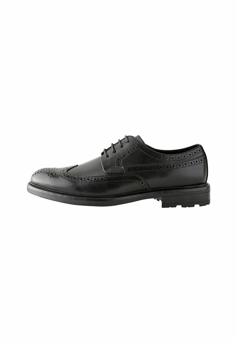 Chaussure brogue en cuir noir avec perforations décoratives, design à lacets, bout arrondi et semelle en caoutchouc texturé pour une meilleure adhérence.