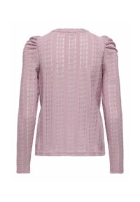 Lilla langermet topp med vertikale blomsterbånd av blonder og lett puffede skuldre, vist fra baksiden mot en hvit bakgrunn.