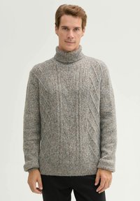 Grauer Strickpullover mit hohem Kragen, der ein strukturiertes Rautenmuster aufweist. Der Stoff sieht weich und dick aus und hat eine lockere Passform.