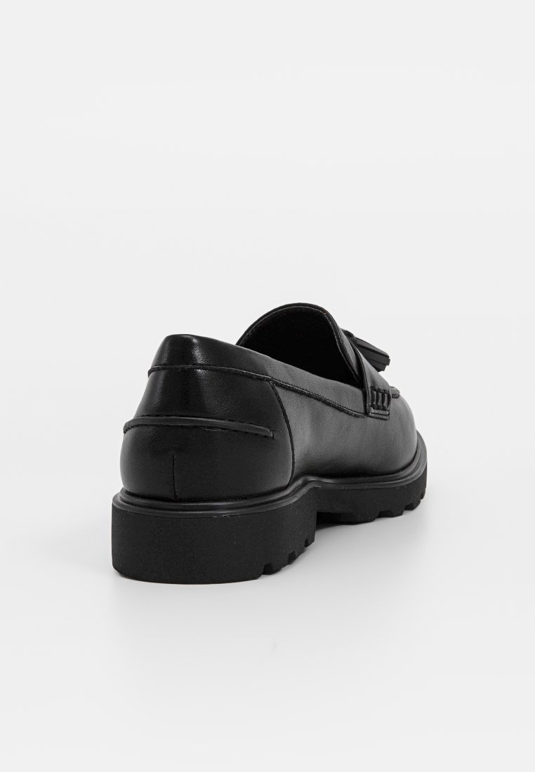 Mocassini in pelle nera con superficie texture, punta arrotondata e una suola spessa e durevole in gomma. Presentano una fascia decorativa sulla parte superiore.