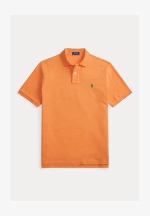 Polo arancione in cotone, con colletto classico, pattina con due bottoni, maniche corte e piccolo logo verde sul petto.