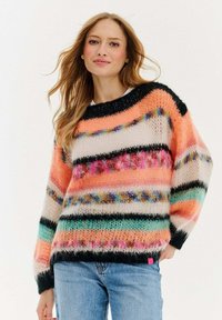 Sweter w wielokolorowe paski, charakteryzujący się miękką, przypominającą moher teksturą. Kolory obejmują koralowy, czarny, biały i zielony. Ze ściągaczem w okolicy szyi i na mankietach.