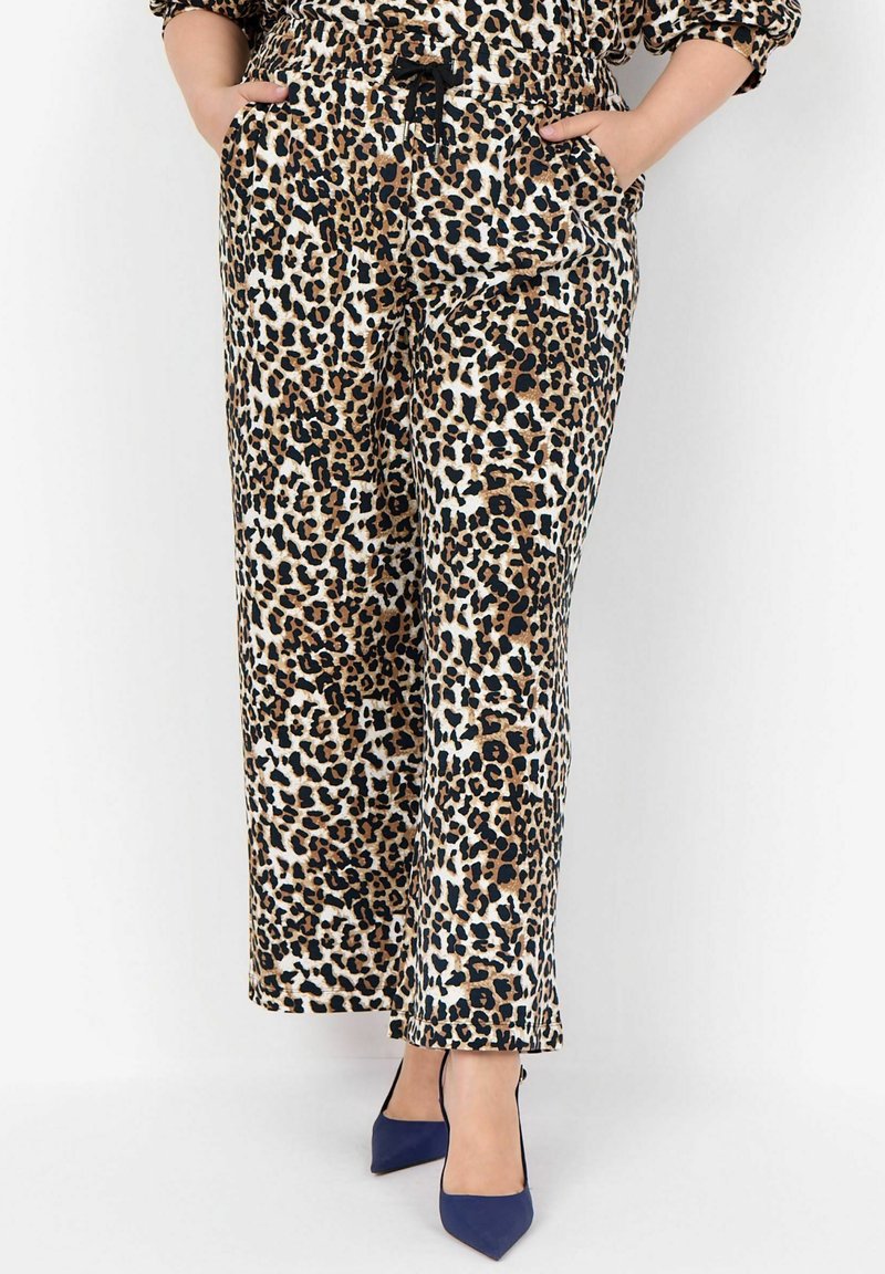 Leopardenmuster weite Hose mit elastischem Bund, zwei Seitentaschen und einer weichen Stofftextur. Getragen mit blauen High-Heels.