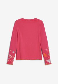 Rosa gestreiftes Langarmoberteil mit fransigem Saum und bunten bestickten Designs an den Ärmeln, einschließlich Früchten, Blumen und Sternen.