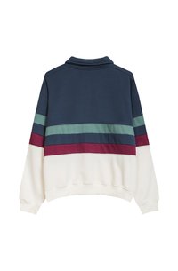 De sweatshirt heeft een marineblauwe bovenkant met horizontale strepen in teal, bordeauxrood en crème. Gemaakt van zachte stof met een relaxte pasvorm en kraag.