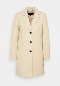 Cappotto in misto lana beige con rever a punta, tre bottoni frontali, due tasche laterali e una finitura liscia al tatto. Interno foderato.