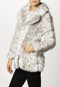Faux fur jacket in shades of gray and white, featuring a plush texture, shawl collar, and side pockets. Soft, relaxed design with loose sleeves.