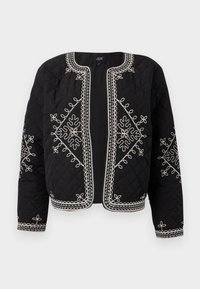 Quilted black jacket featuring white embroidered floral designs. Round neckline, open front, and long sleeves with intricate stitching accents.