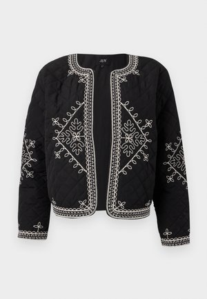 Quiltet svart jakke med hvite broderte blomsterdesign. Rund hals, åpen front og lange ermer med intrikate søm detaljer.