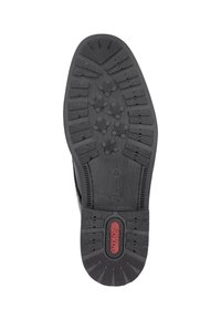 Semelle de chaussure en caoutchouc noir avec un motif texturé présentant des points de grip multidirectionnels et un logo central rouge. Design robuste et plat.