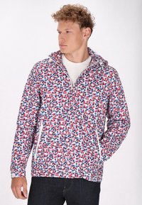 Jachetă multicolor cu un model floral în roșu, albastru și alb. Dispune de un fermoar frontal, glugă și două buzunare laterale cu fermoar.