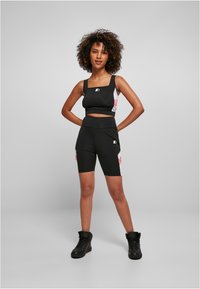 Haut de sport noir crop et short assorti avec des accents roses. Matière lisse et extensible, décolleté carré et design taille haute.