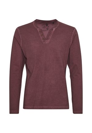 Camicia a maniche lunghe di colore bordeaux in tessuto morbido, con scollo tipo henley e tre bottoni, arricchita da dettagli di cucitura a vista.