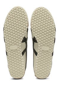 Solevisning af cremefarvede Onitsuka Tiger sko med sorte striber og tekstureret diamantmønster på sålerne.