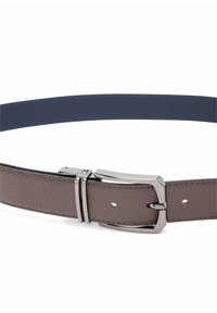 Riem met een bruin gestructureerd leren band en een gladde donkerblauwe binnenkant. Voorzien van een zilverkleurige metalen gesp en dubbele houder.