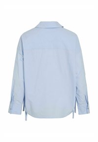 Chemise bleu clair à boutons avec un col classique, des manches longues, des fentes latérales et une texture en coton lisse. Vue de dos mettant en avant un design épuré.