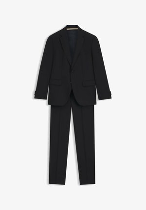 Zwart pak bestaande uit een op maat gemaakte blazer met notch revers en twee voorzakken, gecombineerd met slim-fit broeken. Glad textuur van de stof.