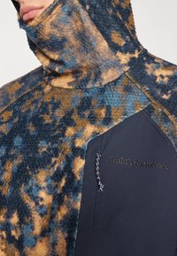 Blauw en bruin fleece pullover met een hoge kraag, voorzien van een gestructureerd patroon, contrasterend donker zijpaneel en merkdetails.