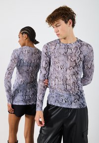 Tricou cu mâneci lungi, având un design cu imprimeu de �șarpe în nuanțe de liliachiu și negru, realizat dintr-un material ușor, texturat, cu o siluetă ajustată.