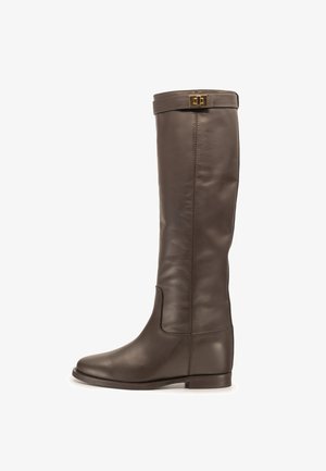 Hoher dunkelbrauner Lederstiefel mit flacher Sohle und goldenem Schnallendetail oben, seitlich auf weißem Hintergrund gezeigt.