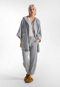 Set de lounge gri, compus dintr-o bluză cu glugă în stil kimono și pantaloni tapered asortați. Material moale cu un finisaj texturat și două buzunare laterale.