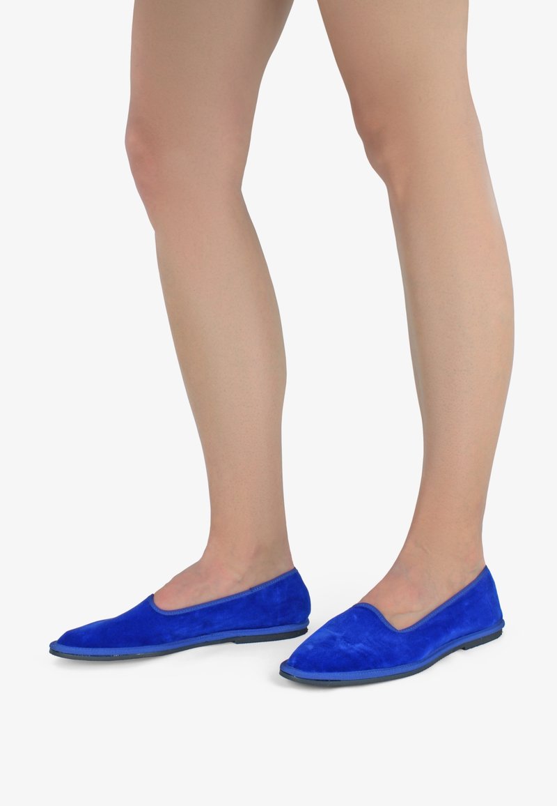 Modré semišové ploché boty s hladkým povrchem, minimalistickým designem, špičatou špičkou a flexibilní černou podešví.