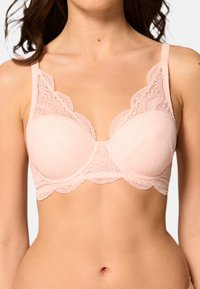 Ljusrosa spetsbh med scallopade kanter, dekorativa mönster och justerbara band; koppdesignen ger strukturerat stöd.