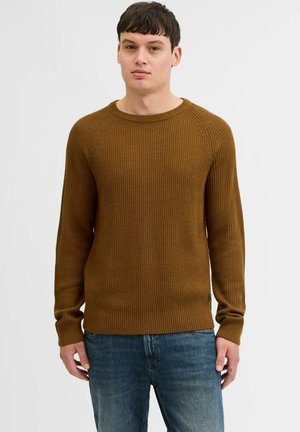 Geribbelde bruine trui met een ronde hals en lange mouwen. Draagt over blauwe jeans, met een aansluitende taille en subtiele logo-detail aan de zoom.