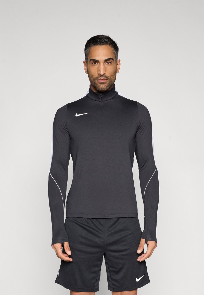 Μαύρο αθλητικό μπλουζάκι με μακριά μανίκια και ψηλό γιακά, με λευκές λεπτομέρειες στα πλευρά και φερμουάρ εμπρός. Συνδυάζεται με μαύρο σορτς που φέρει λογότυπο.