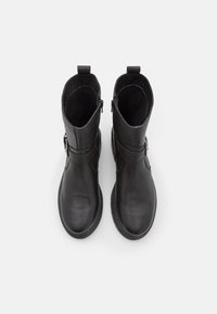 Black leather ankle boots with a textured finish, side zip closure, and a strap detail near the ankle. Flat sole with a round toe.