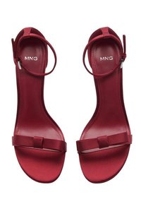Sandali con tacco in satin rosso, con una sottile cinghia alla caviglia, una fascia per le dita piatta con un dettaglio a nodo e una finitura interna liscia.