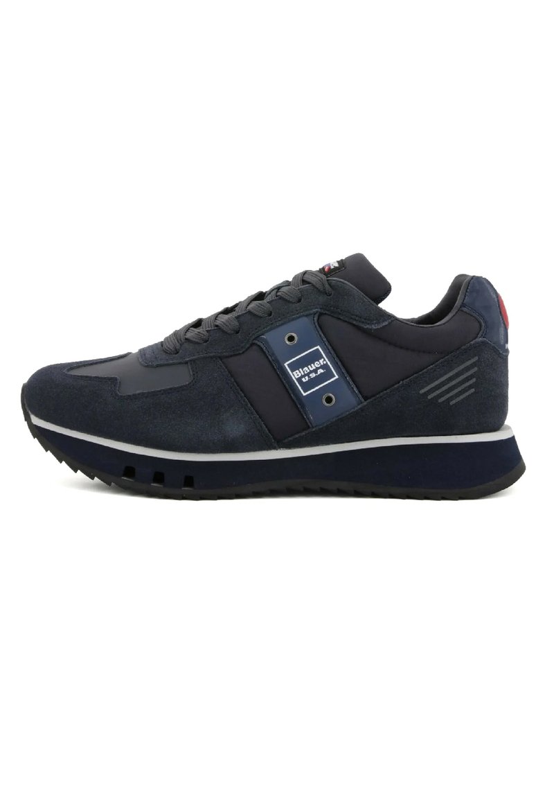Sneaker atletico blu navy caratterizzato da una combinazione di suède e materiali tessili, una suola intermedia bianca e un accento con logo sul lato.