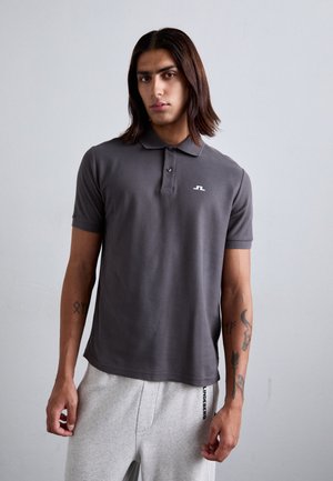 Gray polo shirt with short sleeves, two front buttons, and a small white logo on the left chest. Worn with gray sweatpants featuring side lettering.