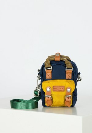 Compact crossbody bag with navy blue and yellow fabric, brown leather accents, metal buckles, and an attached green shoulder strap.