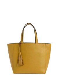Sac fourre-tout en cuir jaune avec deux poignées et un détail de pompon assorti suspendu à l'une des poignées, surface texturée et unie.