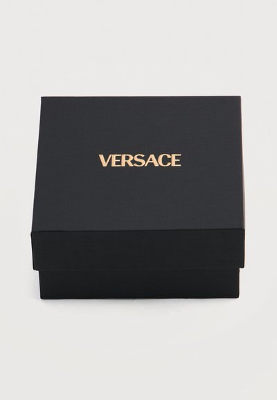 Μαύρο υφασμένο κουτί με χρυσλό λογότυπο VERSACE στο κέντρο του καπακιού, πάνω σε απλό λευκό φόντο.